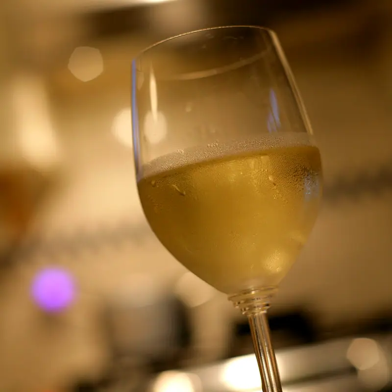 A stemmed glass of pale golden white wine